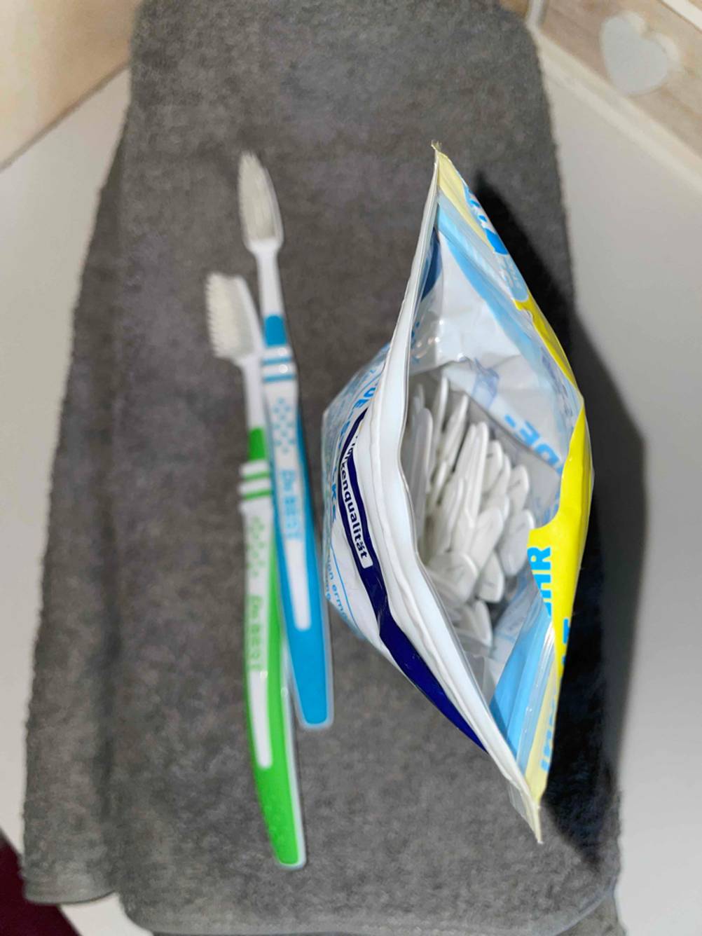 Zahnseide getestet: Eine geöffnete Packung von oben neben zwei Zahnbürsten.