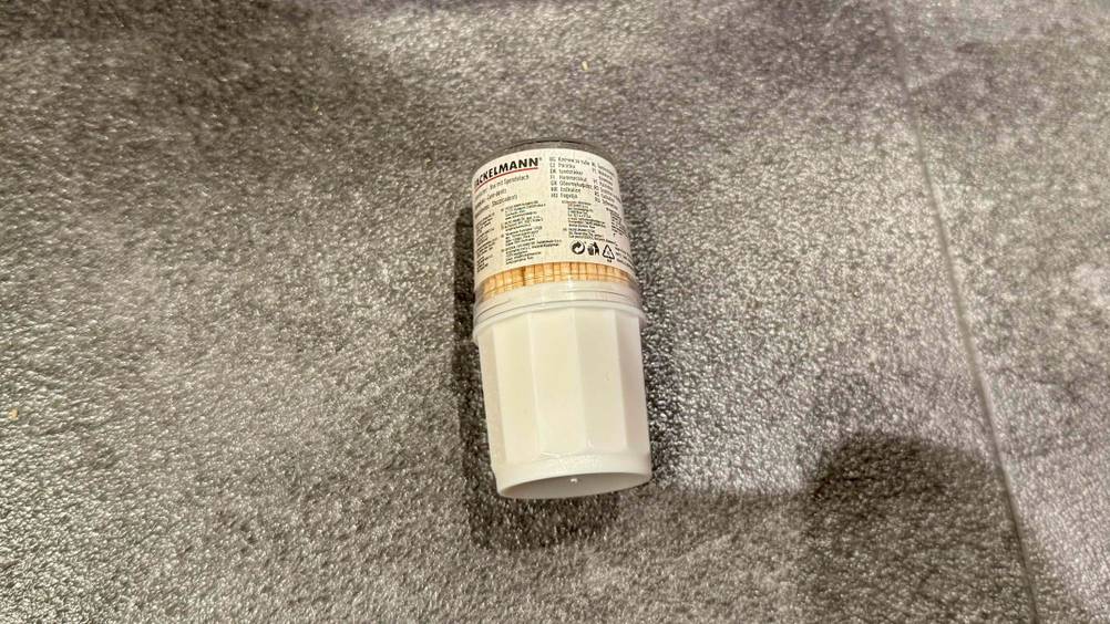 Zahnstocher im Test: Eine Dose liegt auf einem grauen Boden.