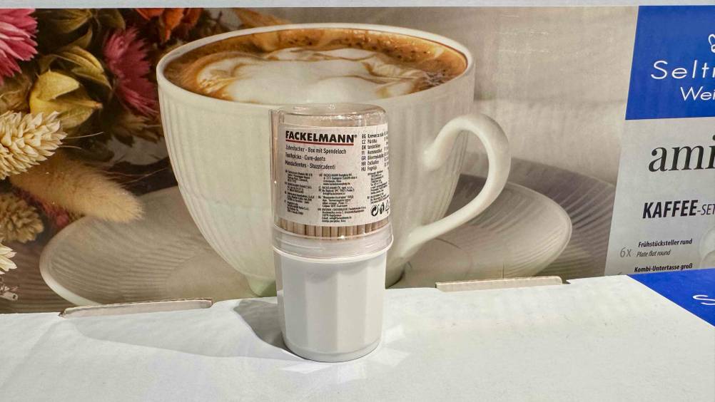 Vor einem Karton mit Kaffetasse steht eine Dose der Zahnstocher im Test.