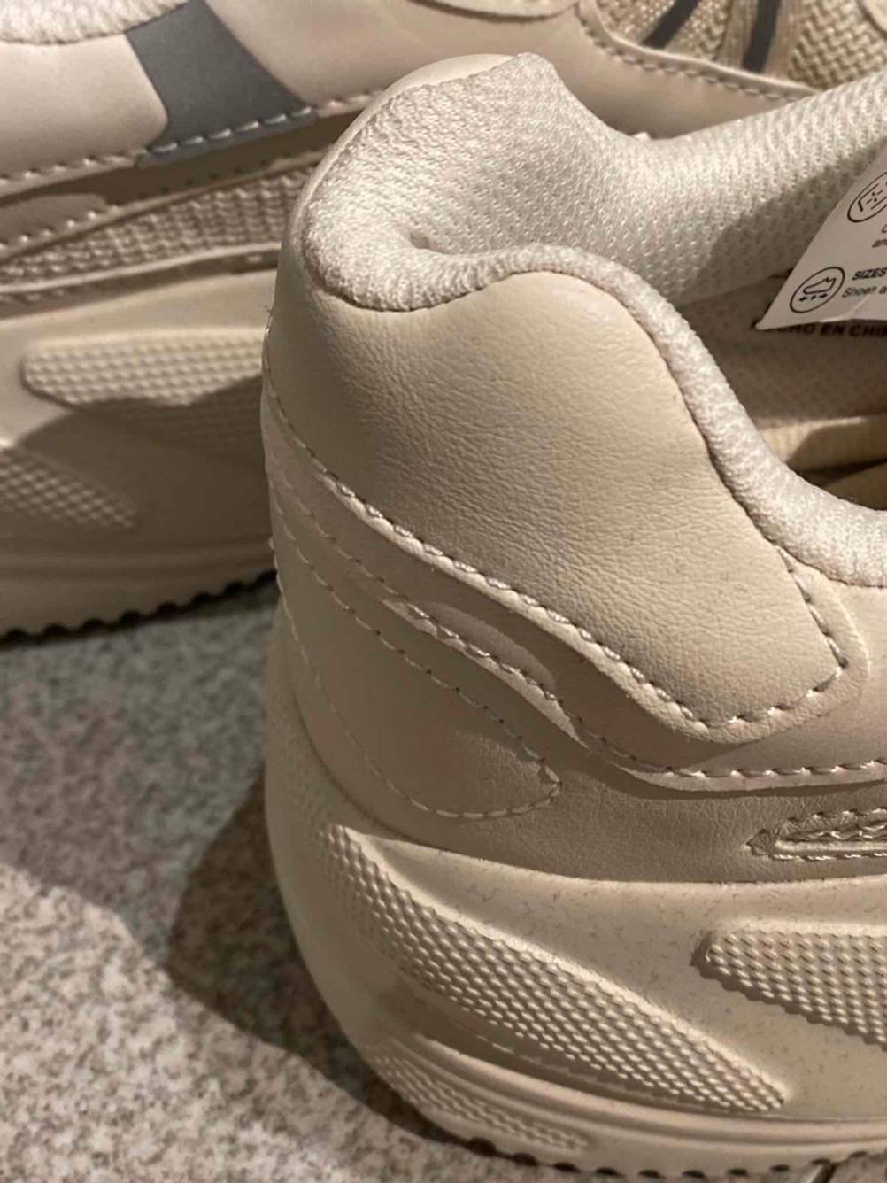 Nahaufnahme des Fersenbereichs von weißen Laufschuhen für Herren im Test.