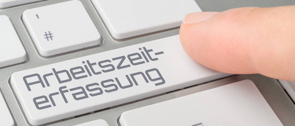Zeiterfassung-Test: Eine Person drückt auf einer Tastatur eine Taste mit der Aufschrift 