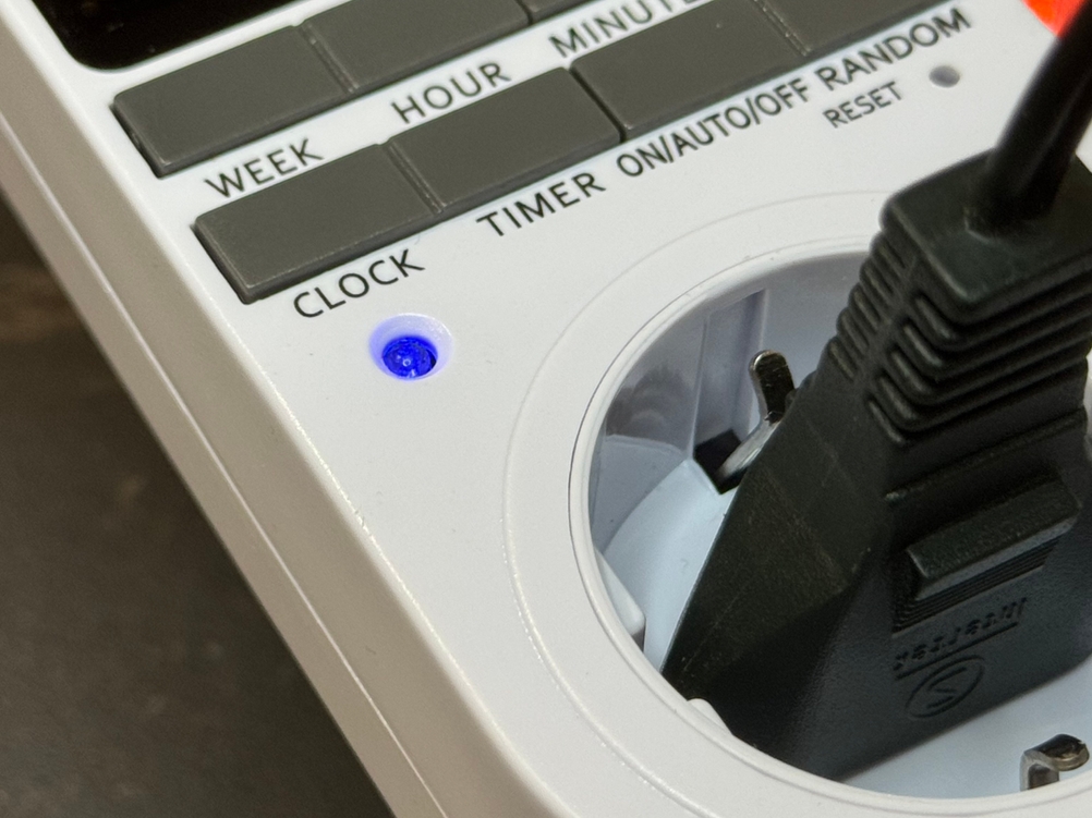 Eine kleine blaue LED leuchtet während des Betriebs der Besvic-Zeitschaltuhr im Test.