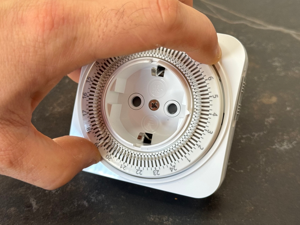 Eine Person dreht am Drehrad der getesteten Zeitschaltuhr von Dewenwils.