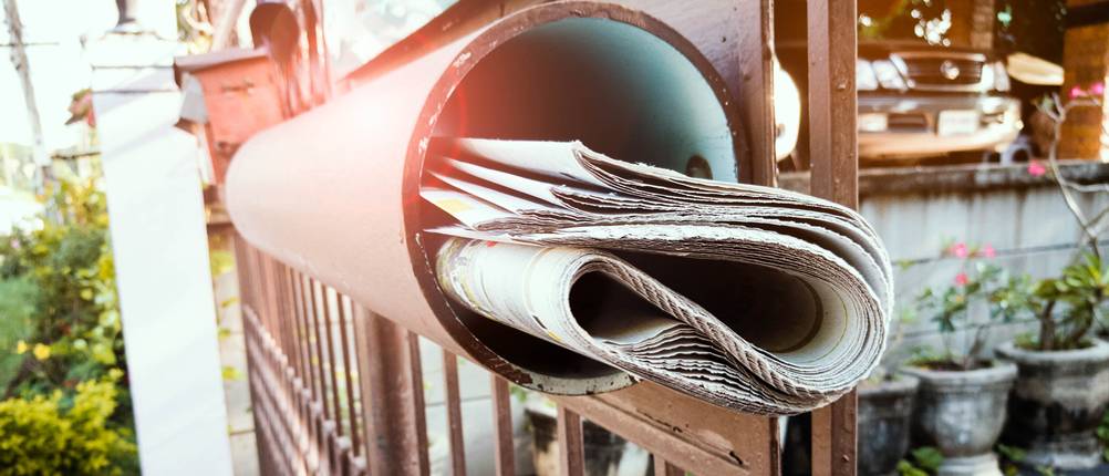 Zeitungsrolle-Test: Eine Zeitungsrolle aus Metall montiert an einem optisch ähnlichen Gartentor.