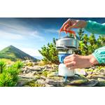 Zeltheizung-Test: Ein Camping-Wasserkocher mit einer Gaskartusche vor einer Bergkulisse.