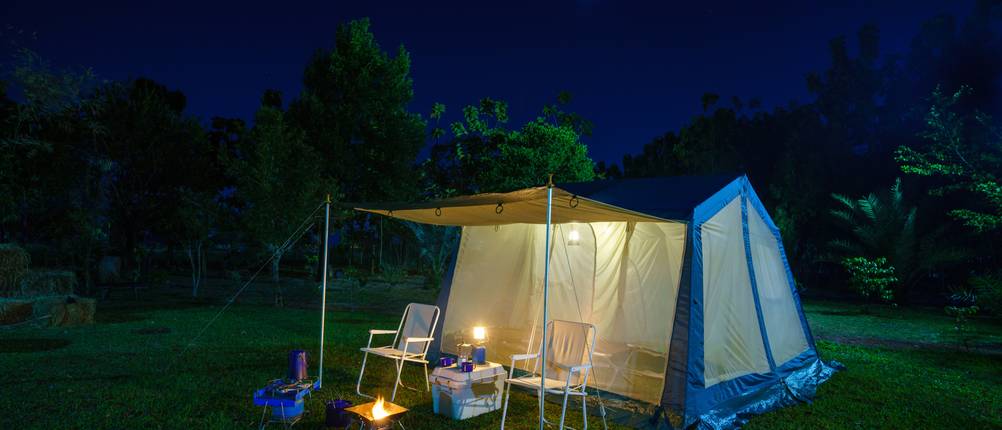 Zeltlampe-Test: Ein großes Zelt mit einem Tisch, Stühlen und diversen Leuchtmitteln.