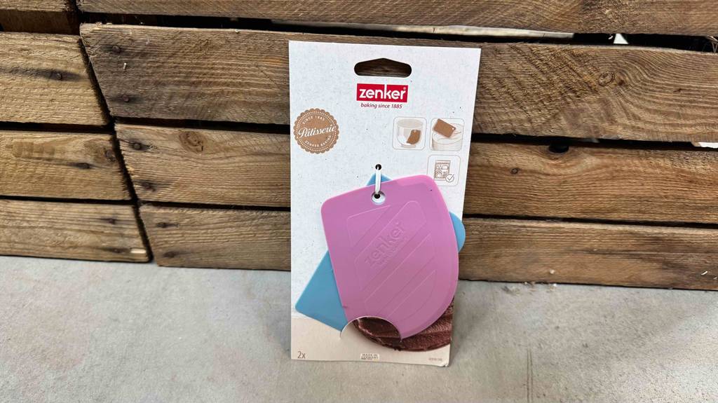 Ein im Kartonblister verpacktes getestetes Teigkarten-Set lehnt an Holzlatten.