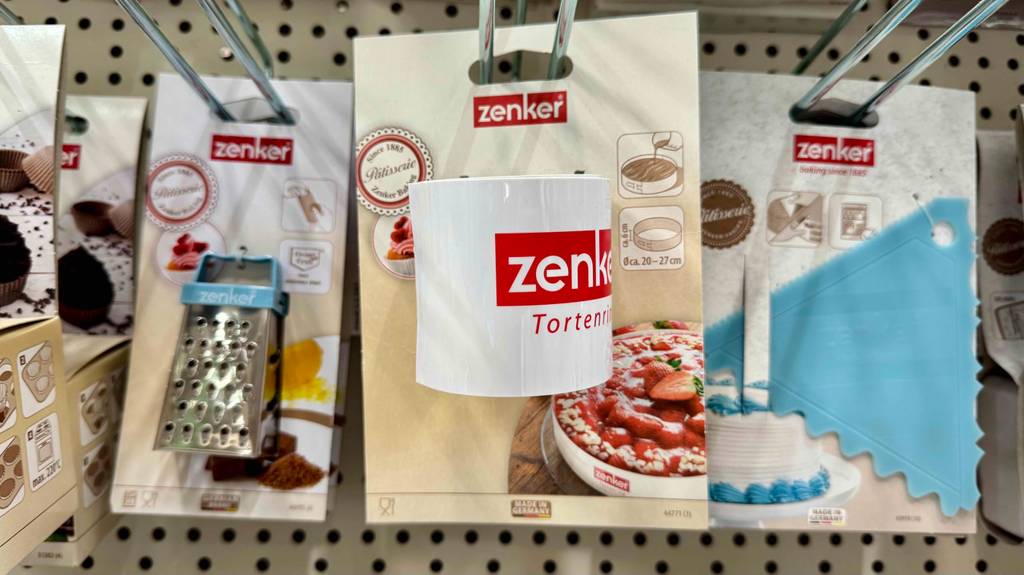 Ein Tortenring hängt zum testen zwischen anderen Produkten in einem Hängeregal.