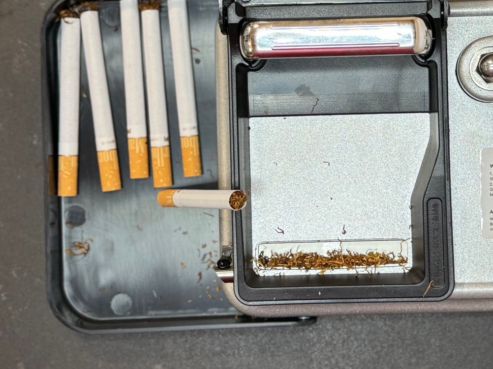 Begrit-Zigarettenstopfmaschine mit fertig gestopften Zigaretten.