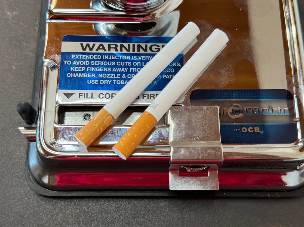 Zwei Zigarettenhülsen liegen auf der getesteten Zigarettenstopfmaschine von OCB.