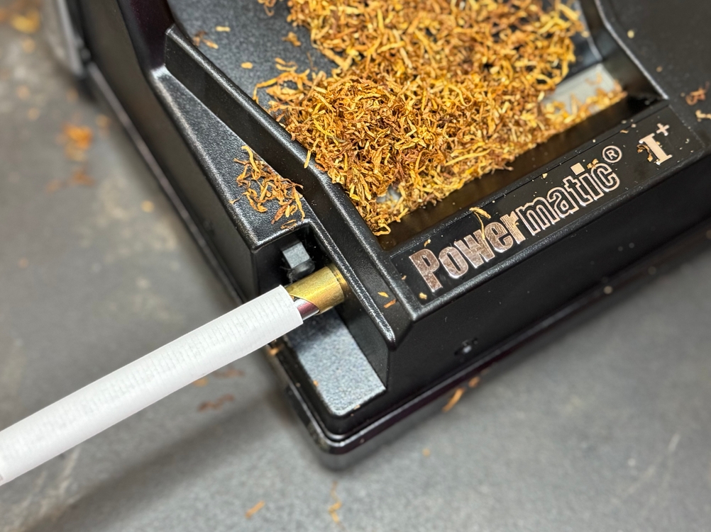 Eine Zigarette wird im Test in der Zigarettenstopfmaschine von Powermatic gestopft.