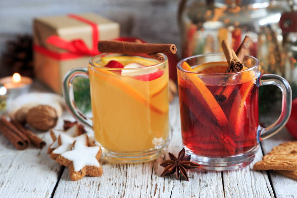 Zimtstangen-Test: Festlich dekorierter Tisch mit Punsch und Glühwein. Um die Tassen liegen Zimtsterne, Sternanis und Zimtstangen.