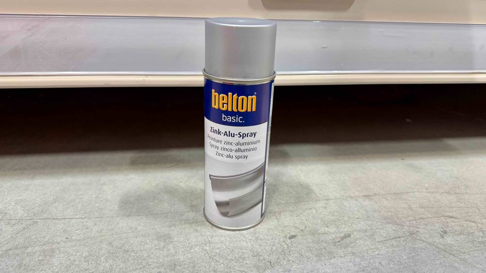 Das getestete Zink-Alu-Spray vor einem Regal auf dem Boden stehend.