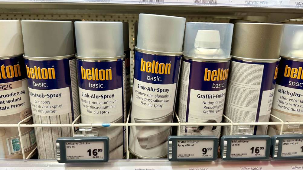 Mehrere Dosen des getesteten Zink-Alu-Sprays in einem Verkaufsregal neben anderen Produkten.