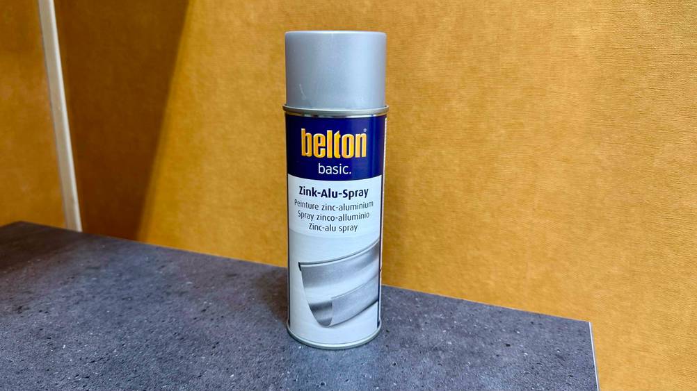 Vor einer gelben Wand steht das Zink-Alu-Spray im Test.