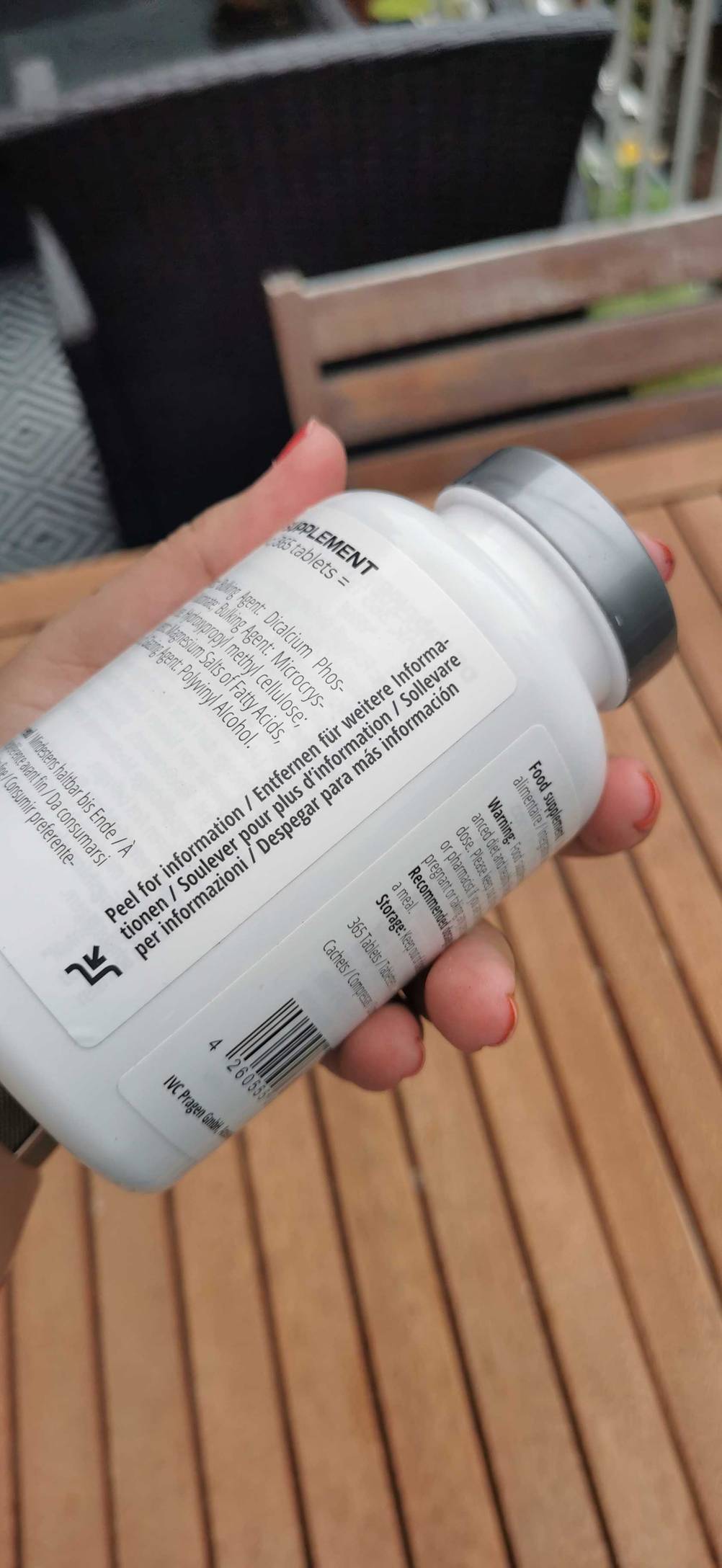 Zinktabletten getestet: Eine Hand hält eine Dose vor einem Holztisch.