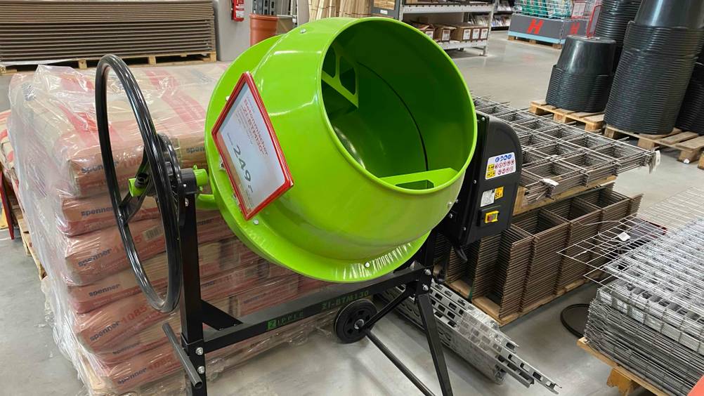 Im Test: Ein grüner Betonmischer von Zipper von schräg vorne mit Preisangabe vor mehreren anderen Produkten in einem Laden.