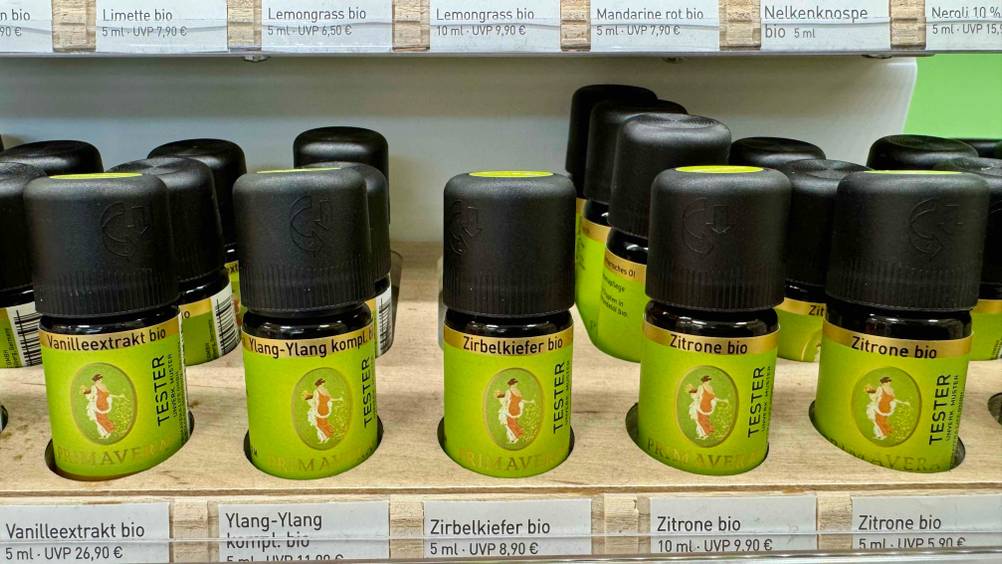 Zirbenöl getestet: Mehrere Fläschchen stehen in einem Verkaufsregal neben anderen Sorten.