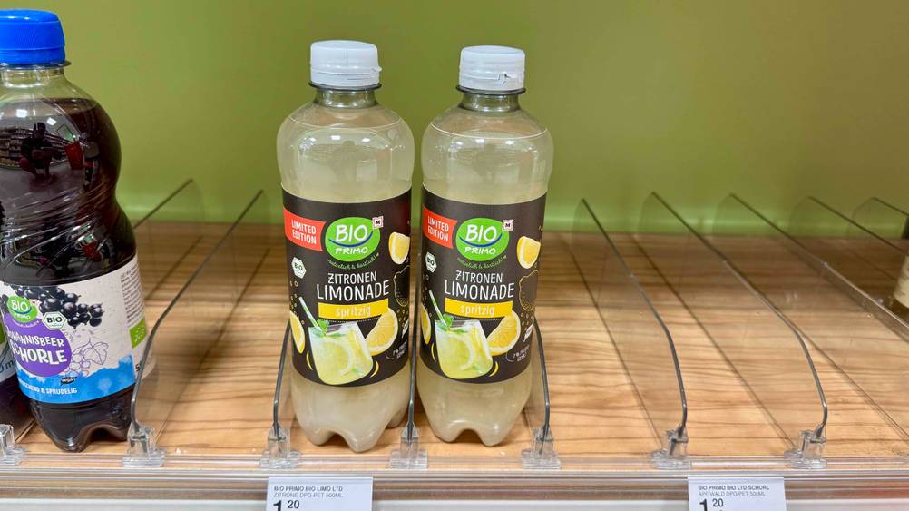 Zwei Flaschen der getesteten Zitronenlimonade in einem Verkaufsregal mit Preisschild.