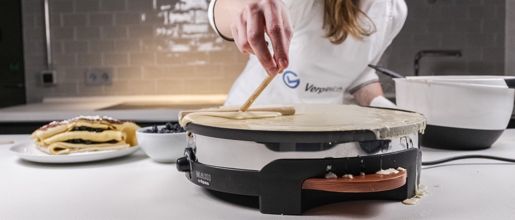 eine Person macht zu viel Teil auf einen Crepes-Maker