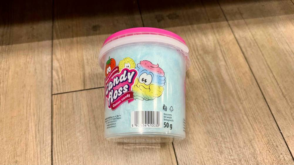 Eine Dose der getesteten Zuckerwatte liegt auf einem Holzboden.