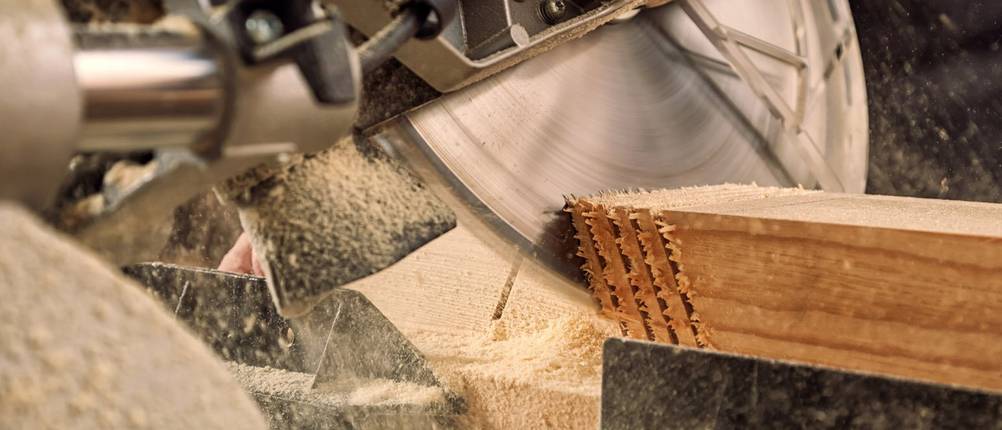 Eine Kappsäge macht mehrere, identische Schnitte in einen Holzkeil.