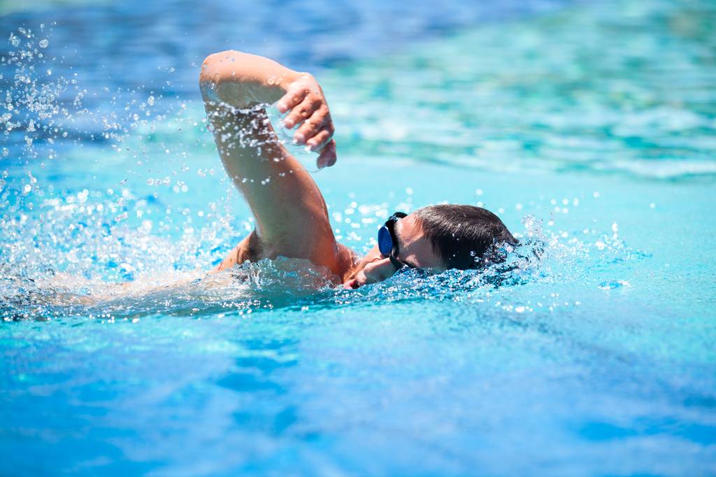 Zugseil Schwimmen Test: Ein Mann übt Kraulen in einem Pool. 