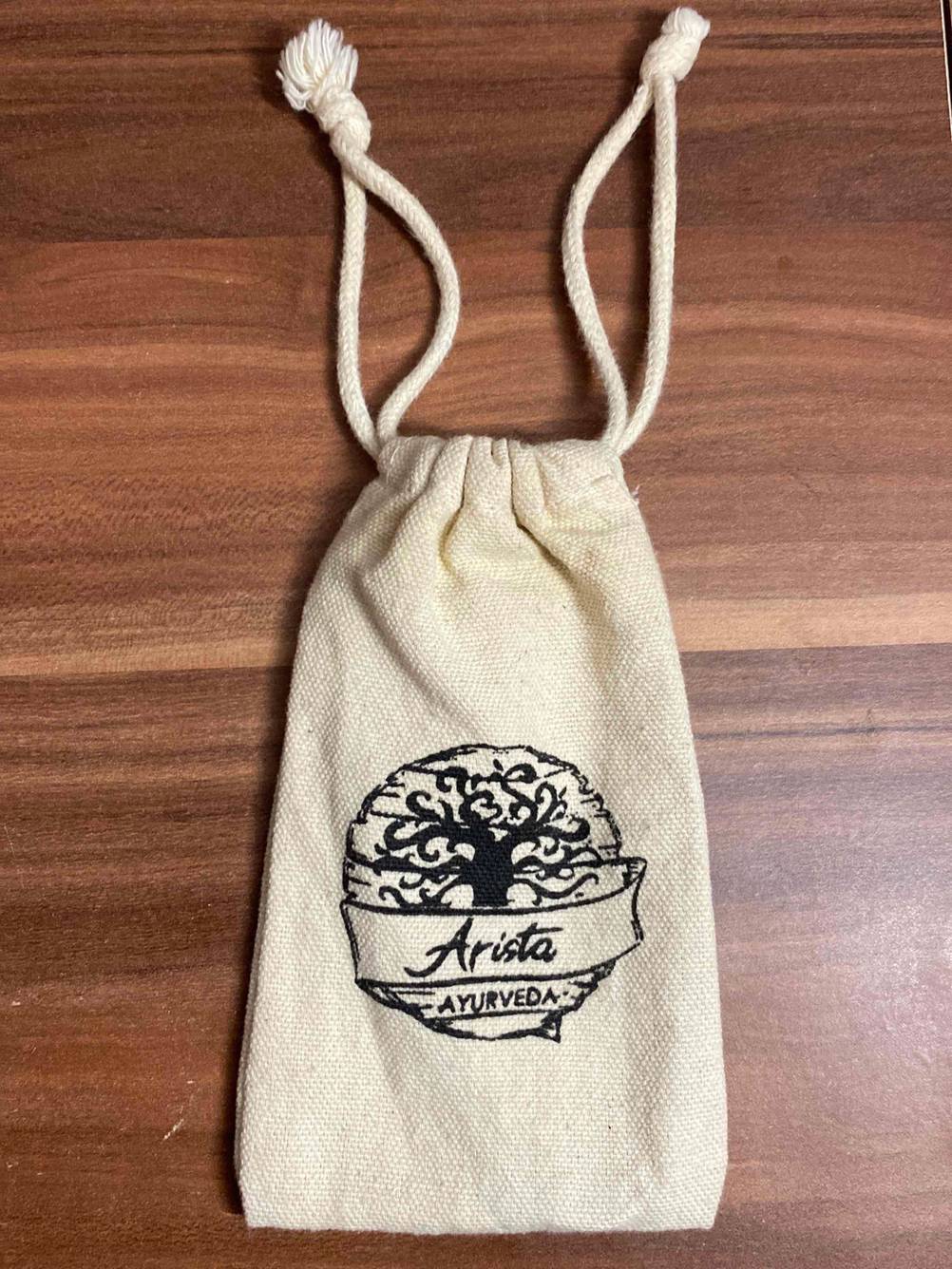 Zungenreiniger getestet: Aufbewahrungsbeutel mit Logo auf einer Holzfläche.