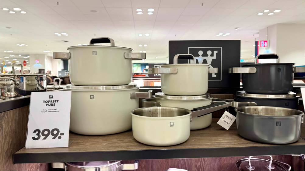 Das getestete Zwilling-Topfset von vorne auf einem Holzregal mit Preisangabe.