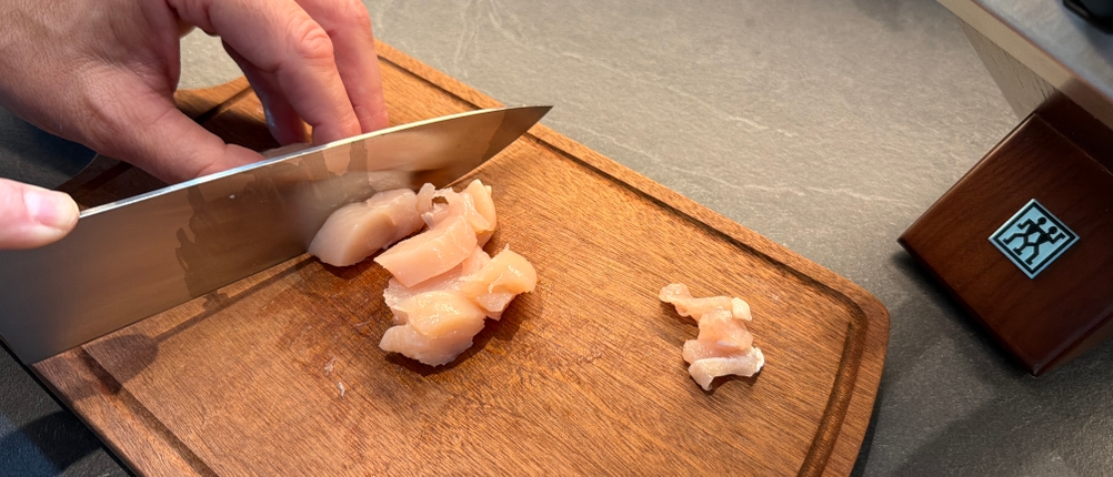 Mit einem Messer aus dem Zwilling-1002451-Messerset wird Fleisch geschnitten.