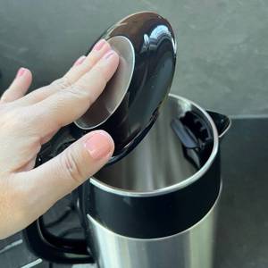 Hand schließt Deckel durch Druck beim Zwilling-1002478