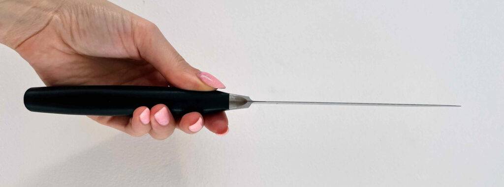 Im Test: ein Zwilling-Messer mit schwarzem Griff in einer Damenhand.