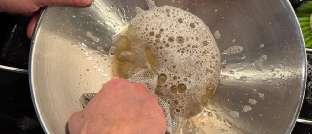 Reinigung der Zwilling-Plus-Wok mit Wasser und Schwamm