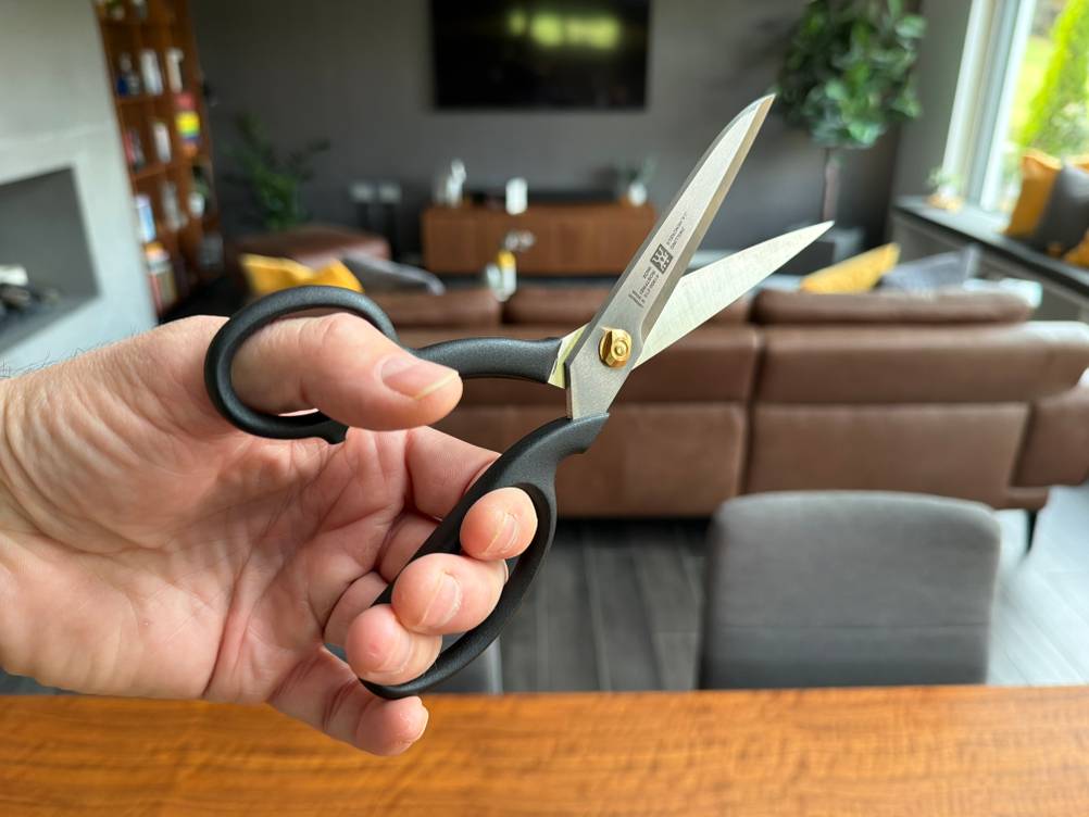 Eine Hand hält die Zwilling-Schneiderschere fest