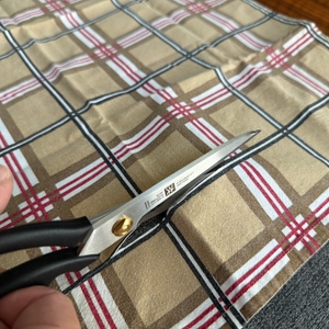 Mit der Zwilling-Schneiderschere wird ein Handtuch zerschnitten