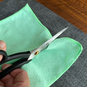 Mit der Zwilling-Schneiderschere wird ein Lappen zerschnitten