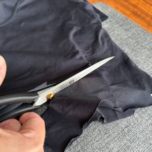 Mit der Zwilling-Schneiderschere wird ein Stoff zerschnitten