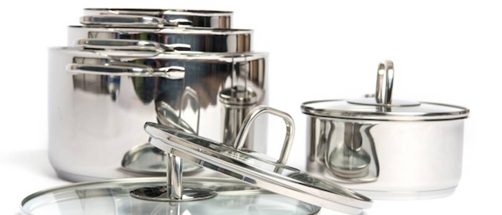Platzbedarf getestet: Auf einem weißen Hintergrund sind drei ineinander gestapelte Töpfe sowie zwei Glasdeckel und ein Stieltopf abgebildet.