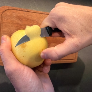 Mit einer Hand wird die Nashi-Birne mit dem Zwilling-Schälmesser geschält.