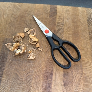 Eine geknackte Walnuss liegt neben der Zwilling Twin L