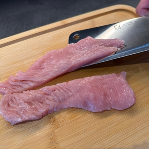 Zwei geschnittene Stücke Fleisch neben dem Zwilling-Twin-Pollux-Hackmesser 30795150