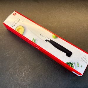 Der Karton vom Zwilling-Vier-Sterne-Spick- und Garniermesser liegt auf einer Küchenarbeitsplatte