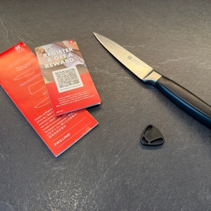 Der Lieferumfang vom Zwilling-Vier-Sterne-Spick- und Garniermesser liegt auf einer Küchenarbeitsplatte