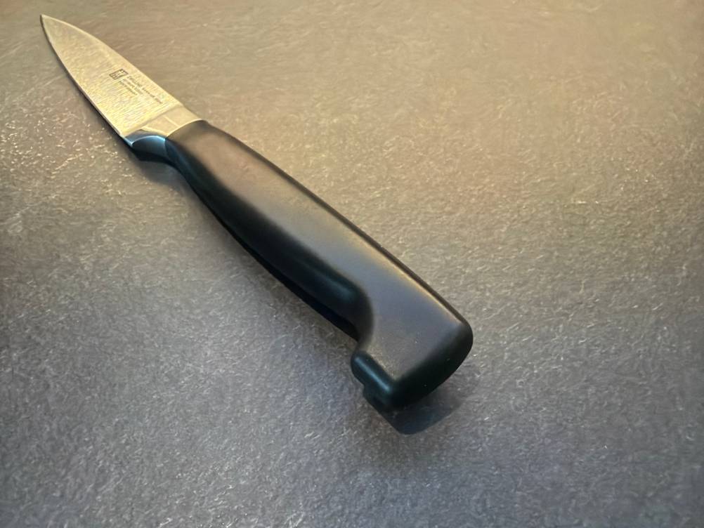 Der Griff vom Zwilling-Vier-Sterne-Spick- und Garniermesser in Nahaufnahme