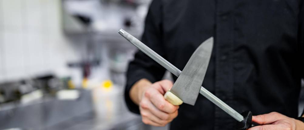 Zwilling-Wetzstahl-Test: Ein Koch schärft ein Messer an einem Wetzstahl