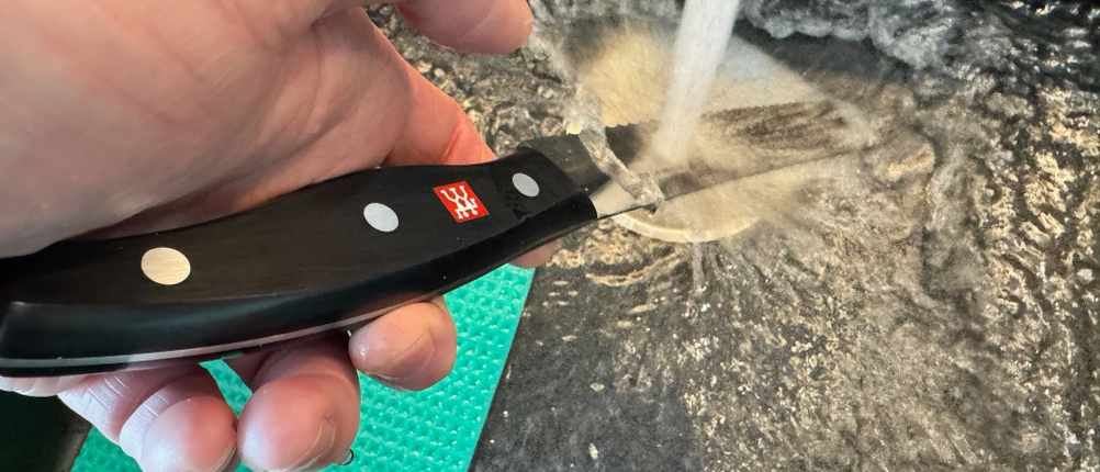 Reinigung des ZwillingTwin-Pollux-Brotmesser mit Wasser