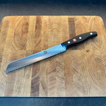 Das Brotmesser Twin Pollux von Zwilling auf einem Brett liegend.
