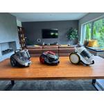 Drei Zyklon-Staubsauger stehen nebeneinander auf einem Tisch