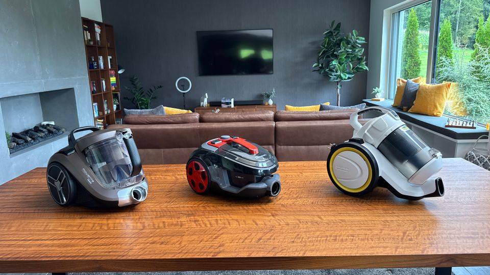 Drei Zyklon-Staubsauger stehen nebeneinander auf einem Tisch