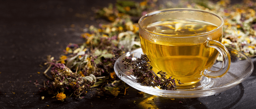 Zyklustee im Test: Eine Tasse Tee, im Hintergrund lose Teeblätter